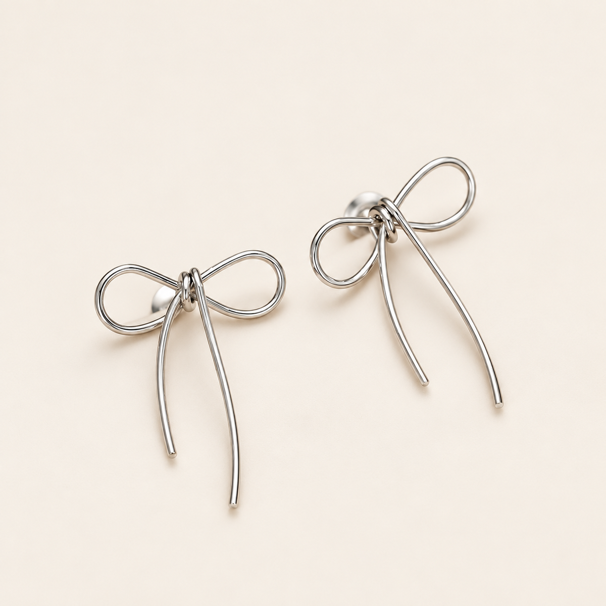 Gold Bow Studs — warm ivory background
