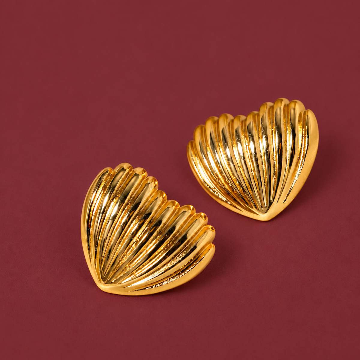 Gold-Tone Shell Studs — muted burgundy background