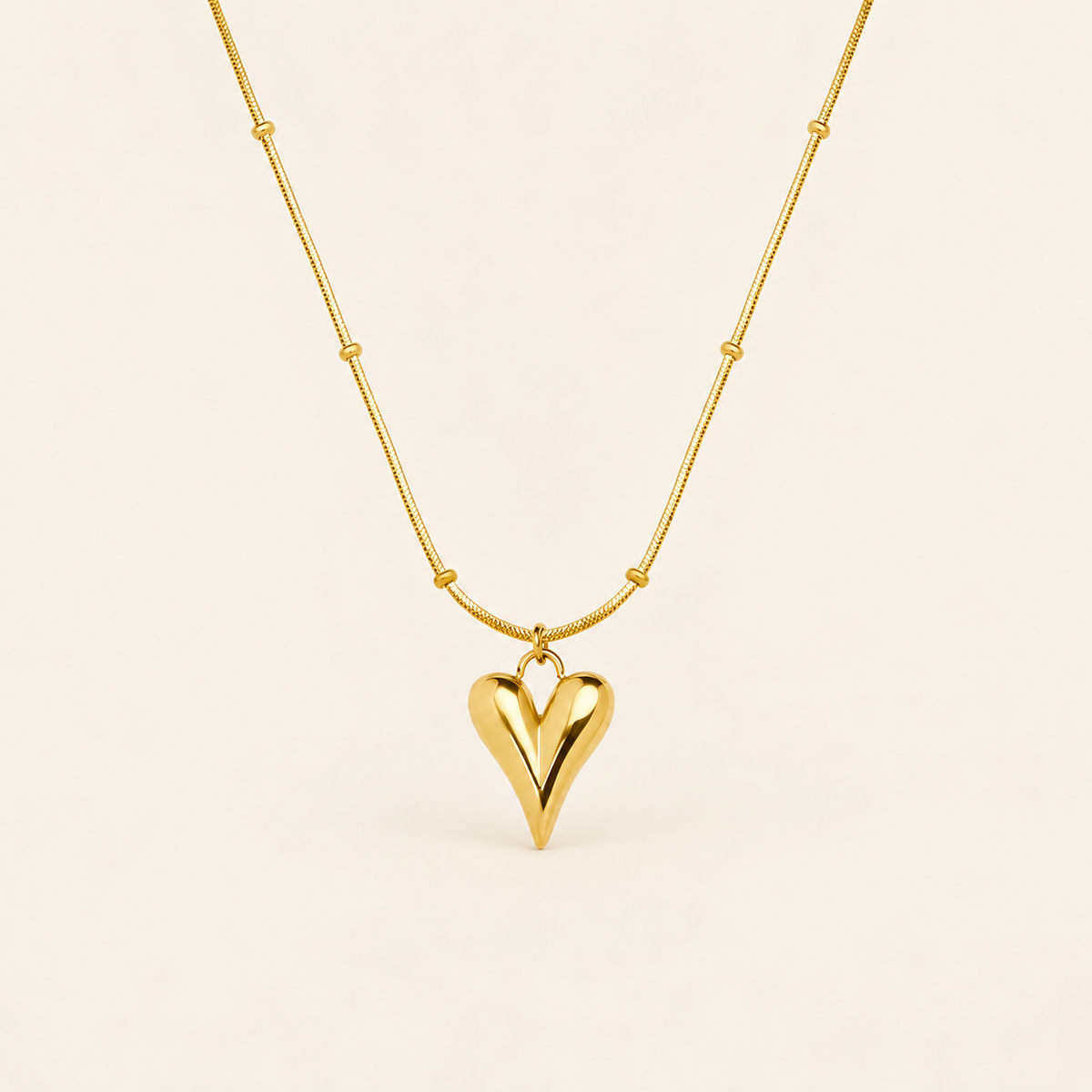 Gold Heart Pendant — warm ivory background