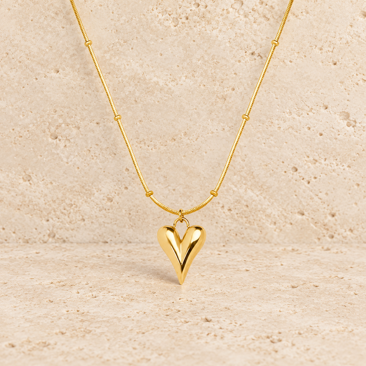Gold Heart Pendant — pale beige natural stone background