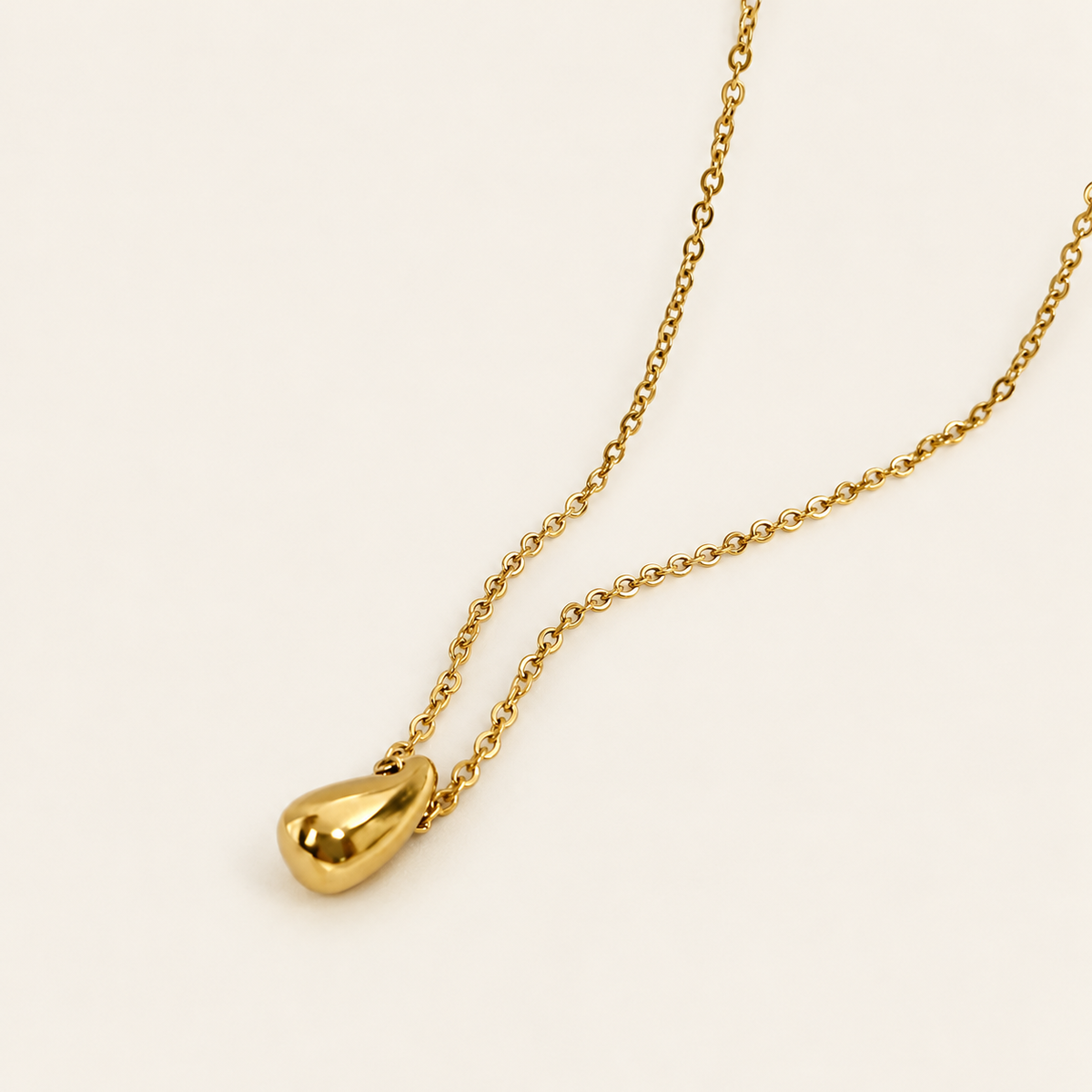Gold Waterdrop Necklace — warm ivory background
