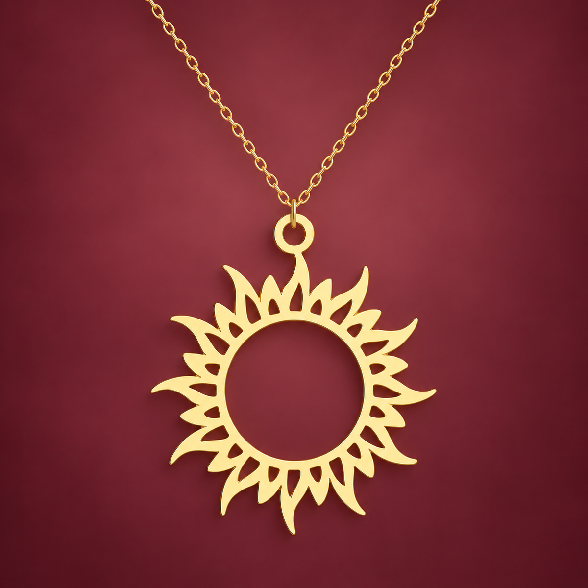 Gold-Tone Sun Symbol Necklace — muted burgundy background