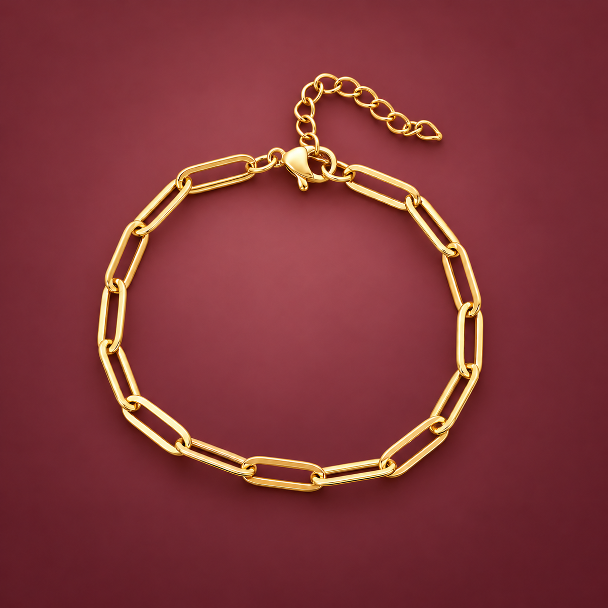 Gold-Tone Paperclip Bracelet — muted burgundy background
