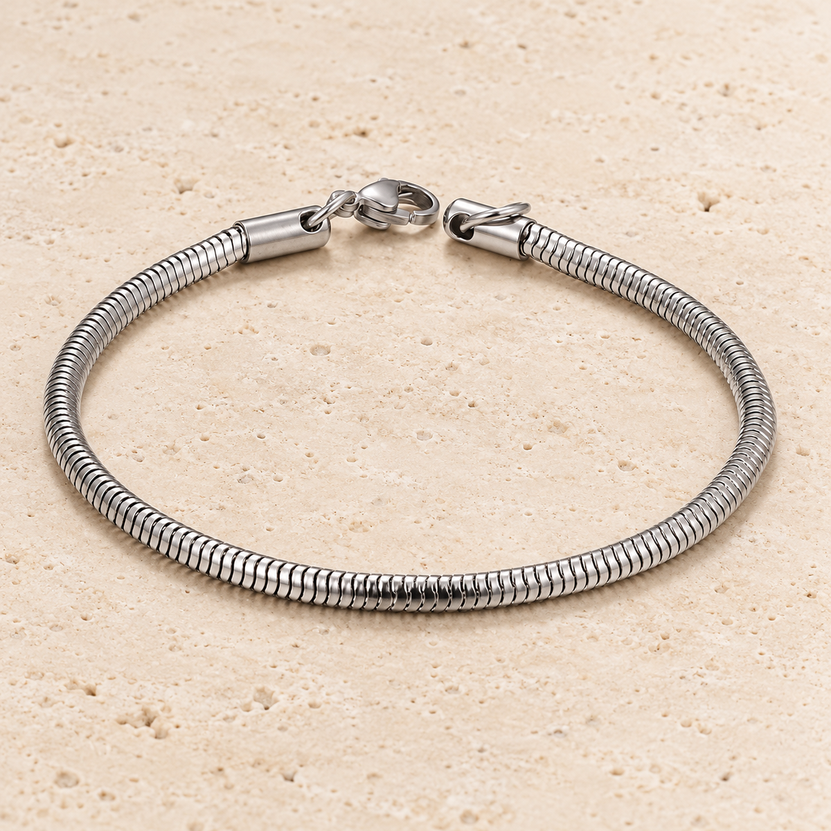 Silver-Tone Snake Chain Bracelet — pale beige natural stone background