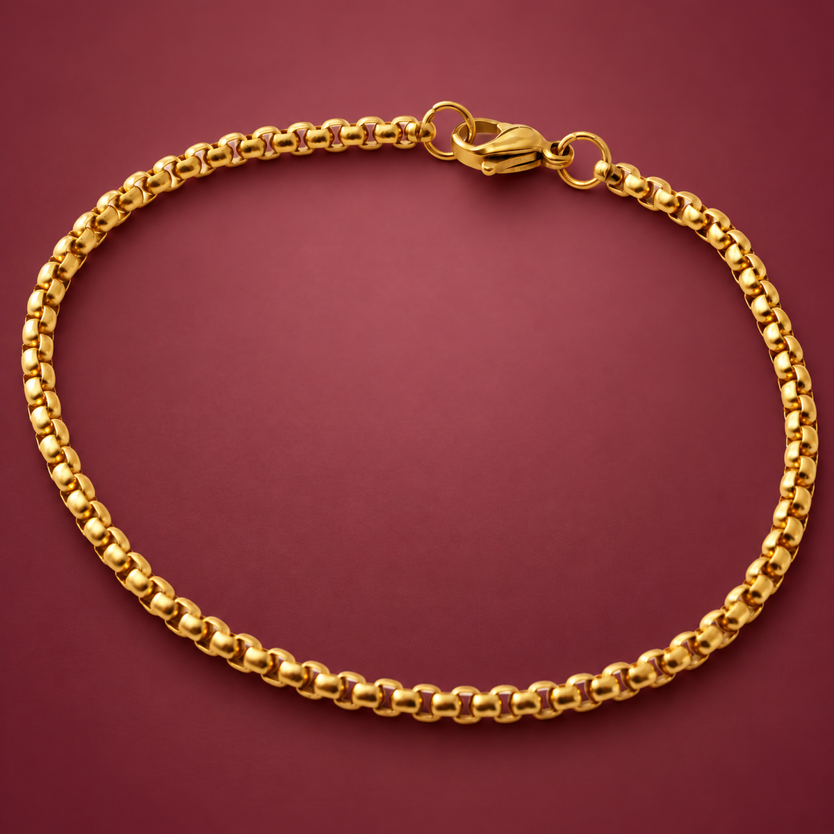 Gold-Tone Rolo Bracelet — muted burgundy background