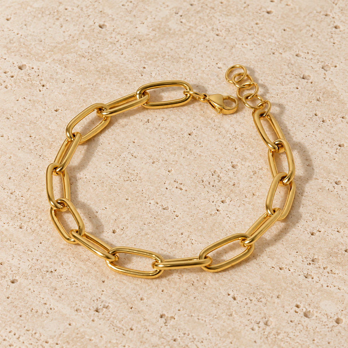 Chunky Gold Paperclip Bracelet — pale beige natural stone background