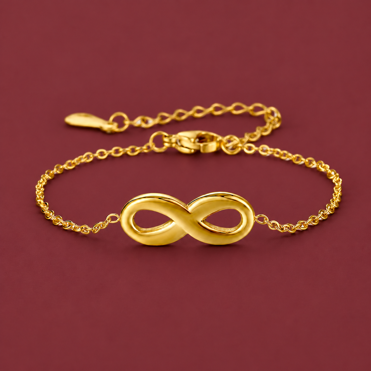 Gold-Tone Infinity Bracelet — muted burgundy background