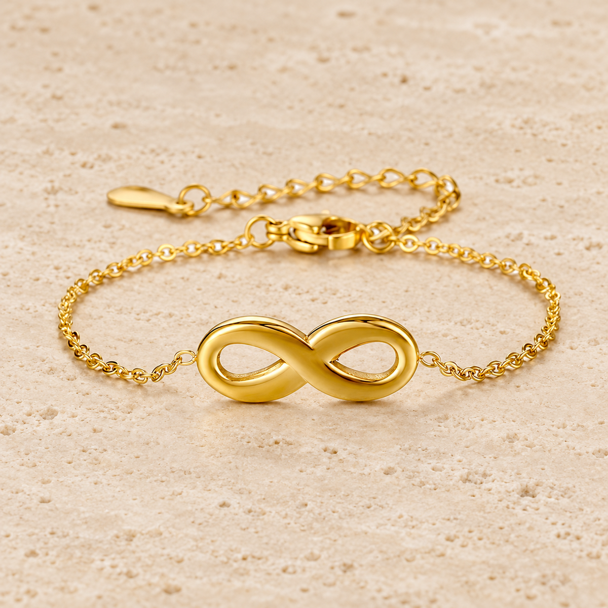 Gold Infinity Bracelet — pale beige natural stone background