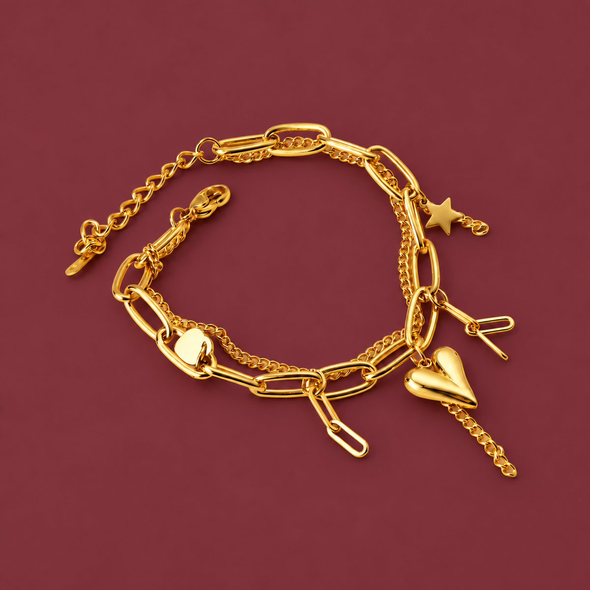 Polished Gold-Tone Charm Bracelet — muted burgundy background