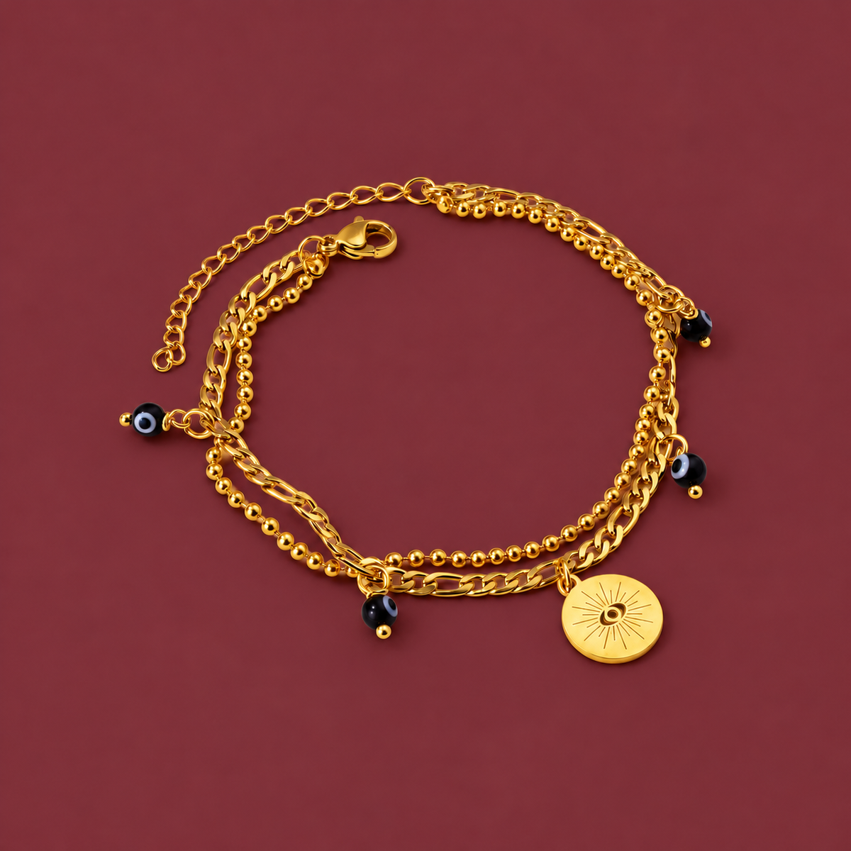 Gold-Tone Link Charm Bracelet — muted burgundy background