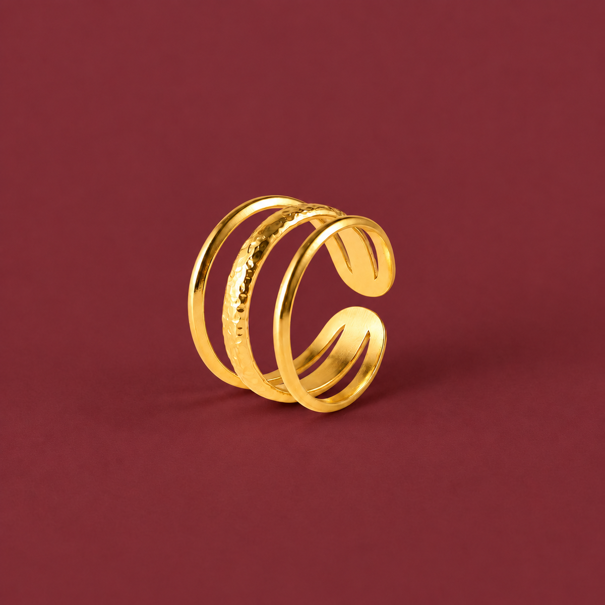 Gold-Tone Triple Line Ring — muted burgundy background