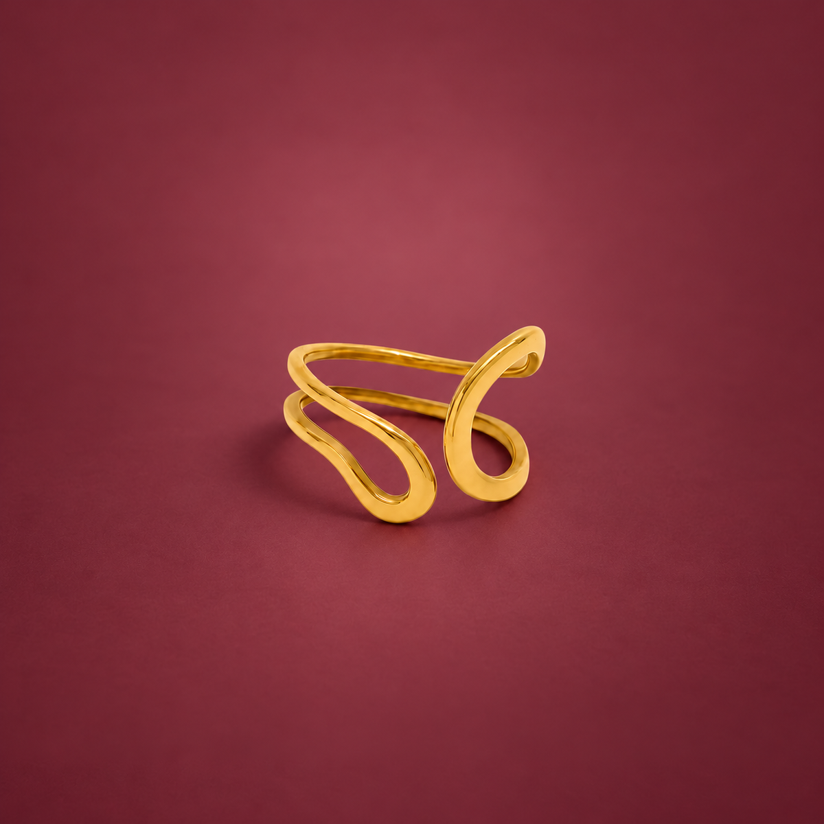 Gold-Tone Open Curve Ring — muted burgundy background