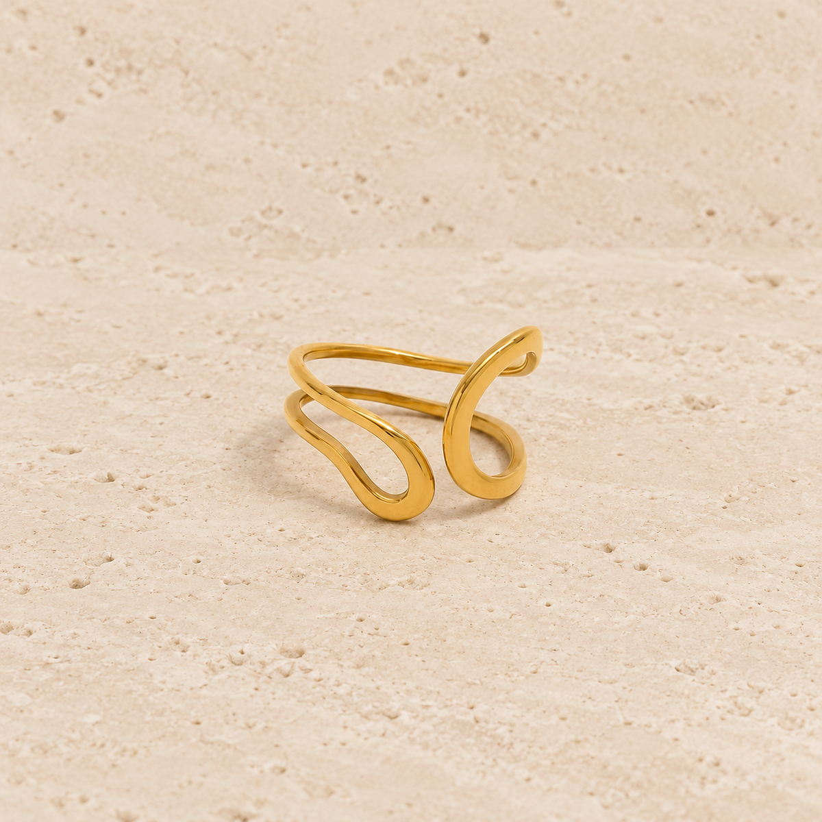 Gold-Tone Open Curve Ring — pale beige natural stone background