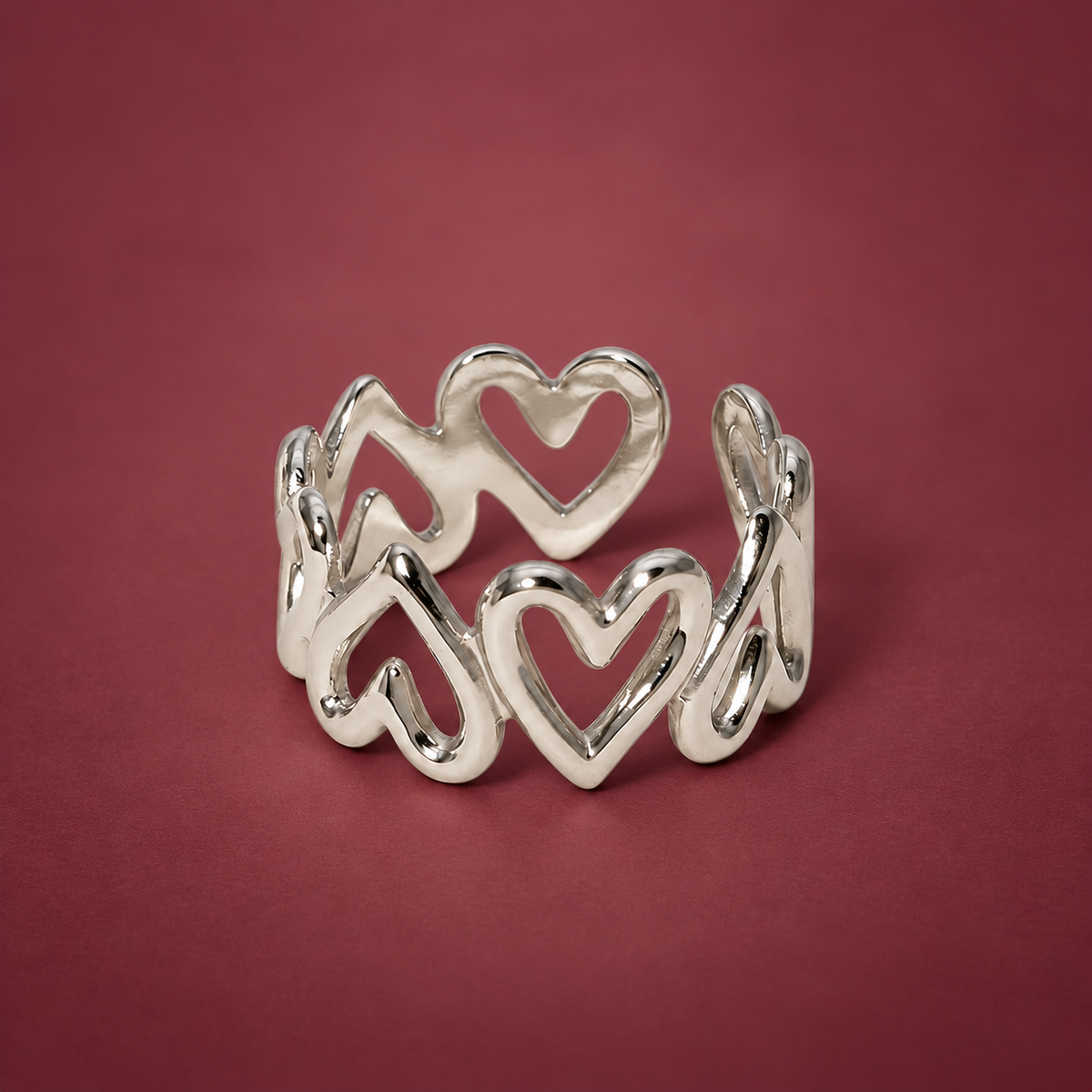 Silver-Tone Heart Band Ring — muted burgundy background