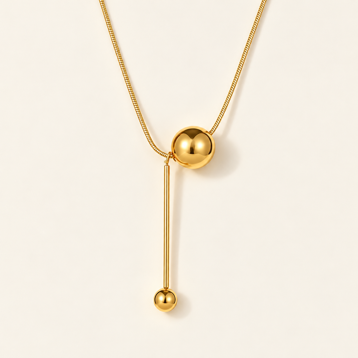 Gold Ball Y Necklace — warm ivory background