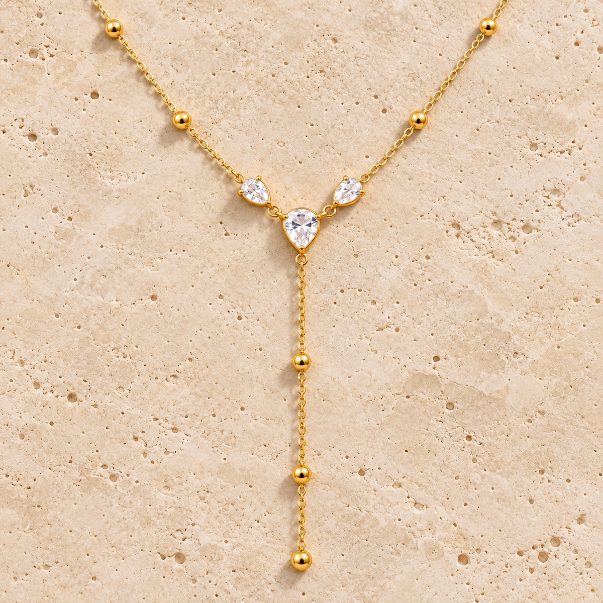 Crystal Heart Y Necklace — pale beige natural stone background