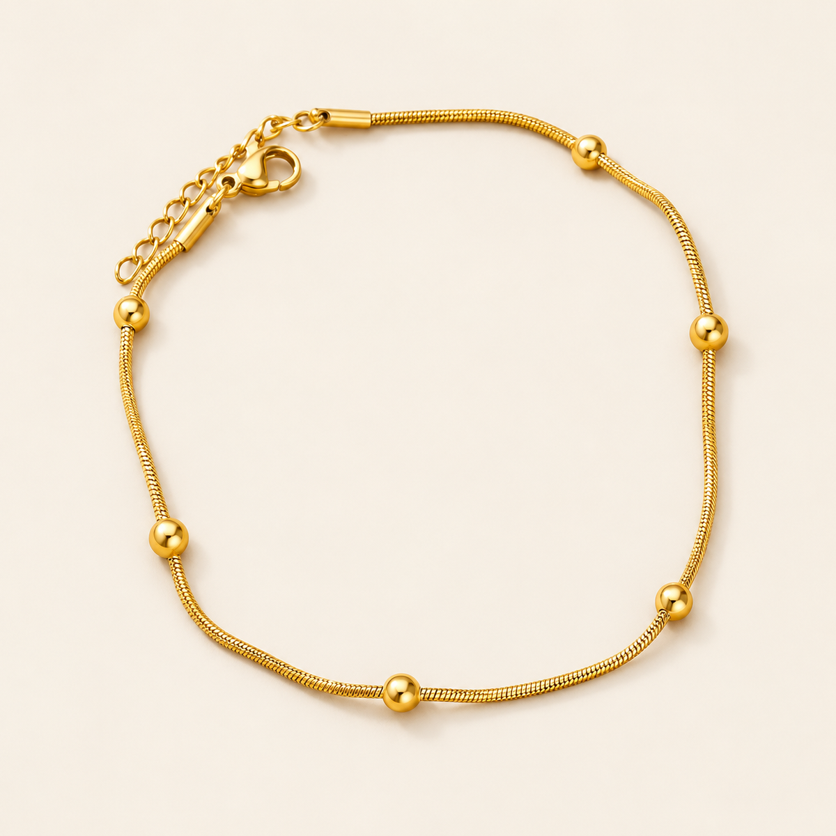 Gold Ball Anklet — warm ivory background