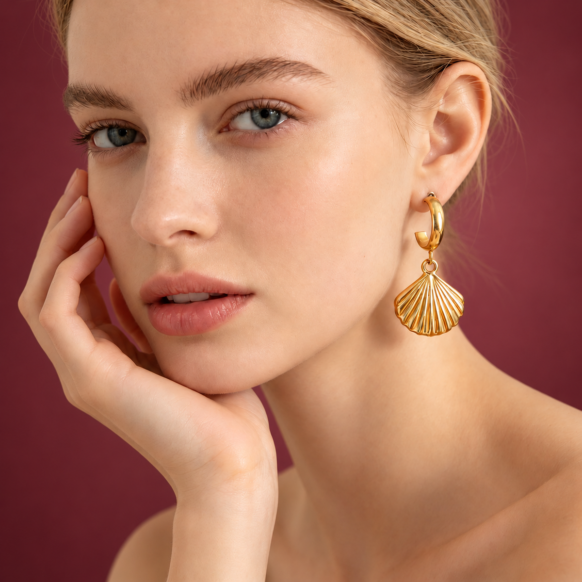 Gold-Tone Fan Shell Earring — muted burgundy background