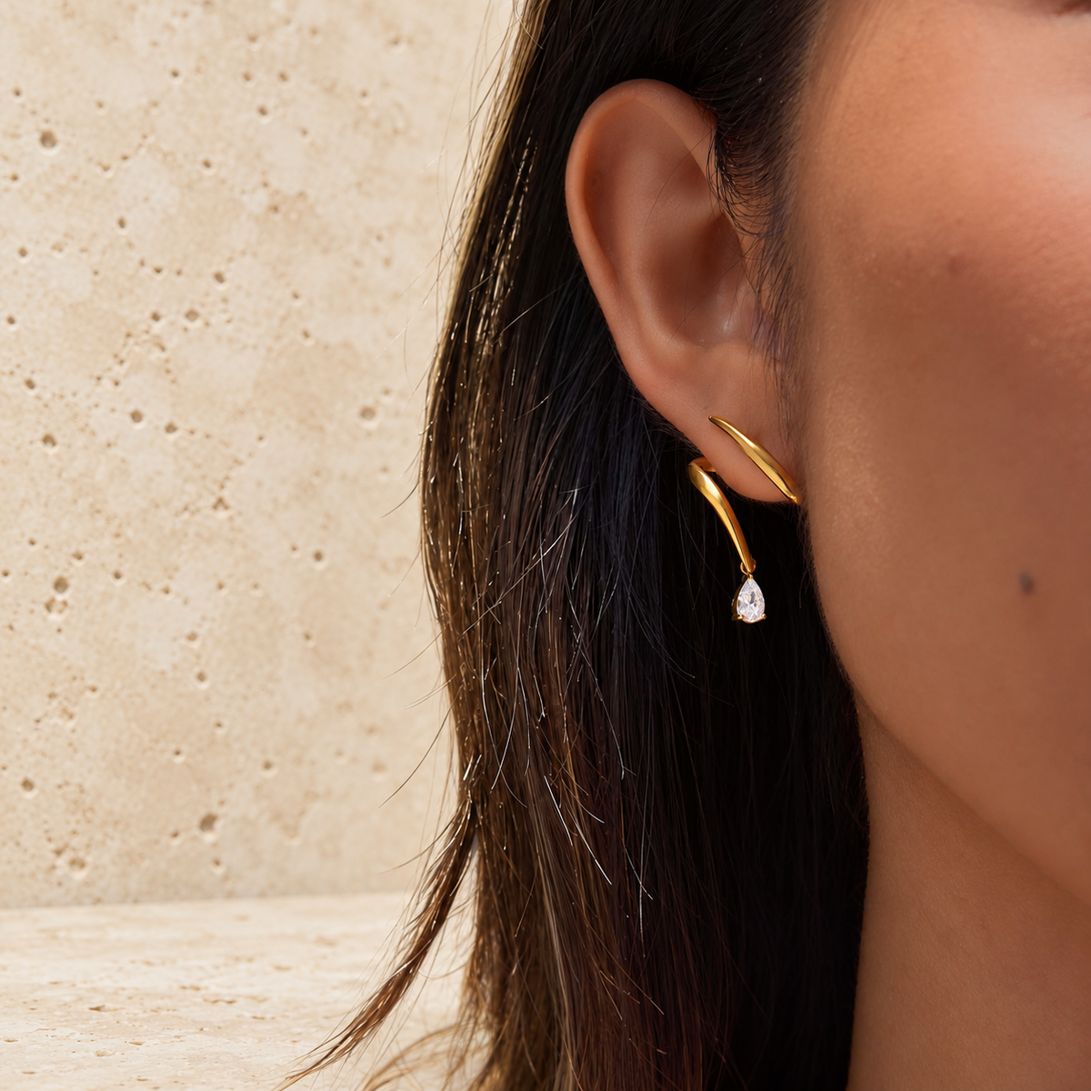 Gold Wave Crystal Earring — pale beige natural stone background
