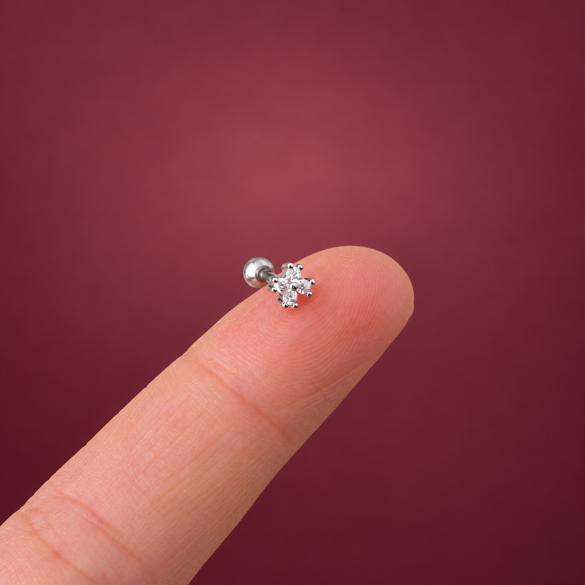 Silver-Tone Flower Cartilage Stud — muted burgundy background