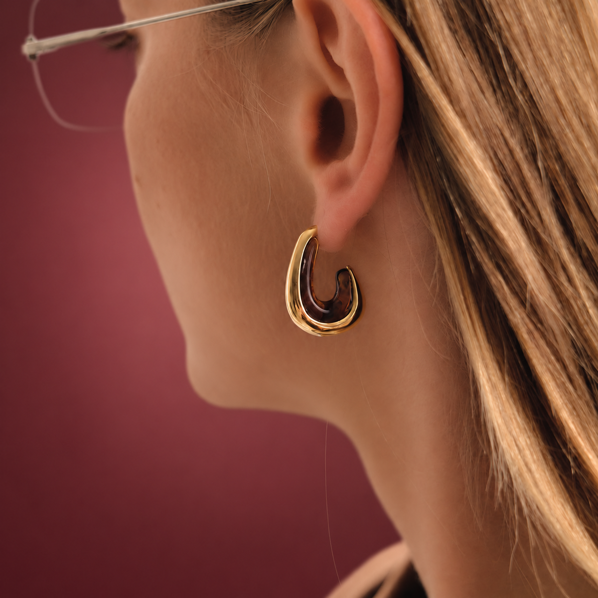 Gold-Tone Resin Hoop Earring — muted burgundy background