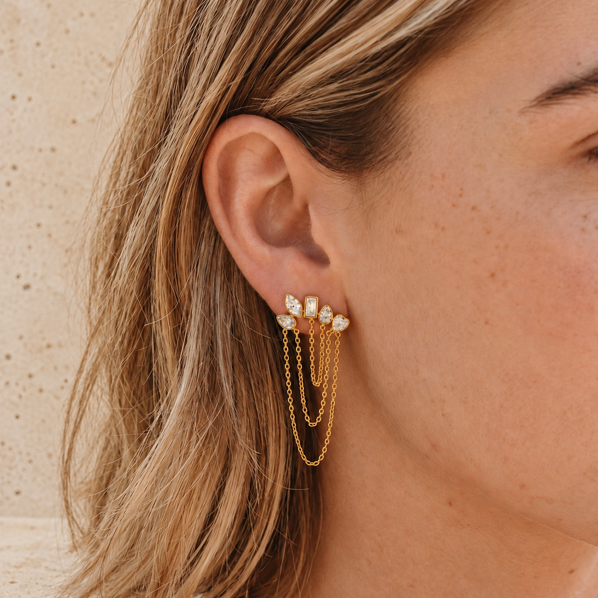 Gold Crystal Cascade Earring — pale beige natural stone background