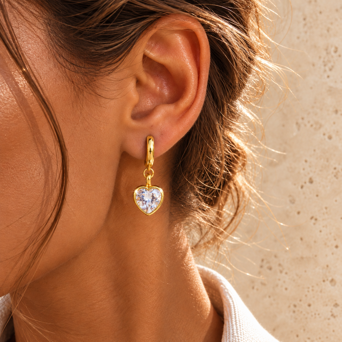 Gold Crystal Heart Drop Earring — pale beige natural stone background