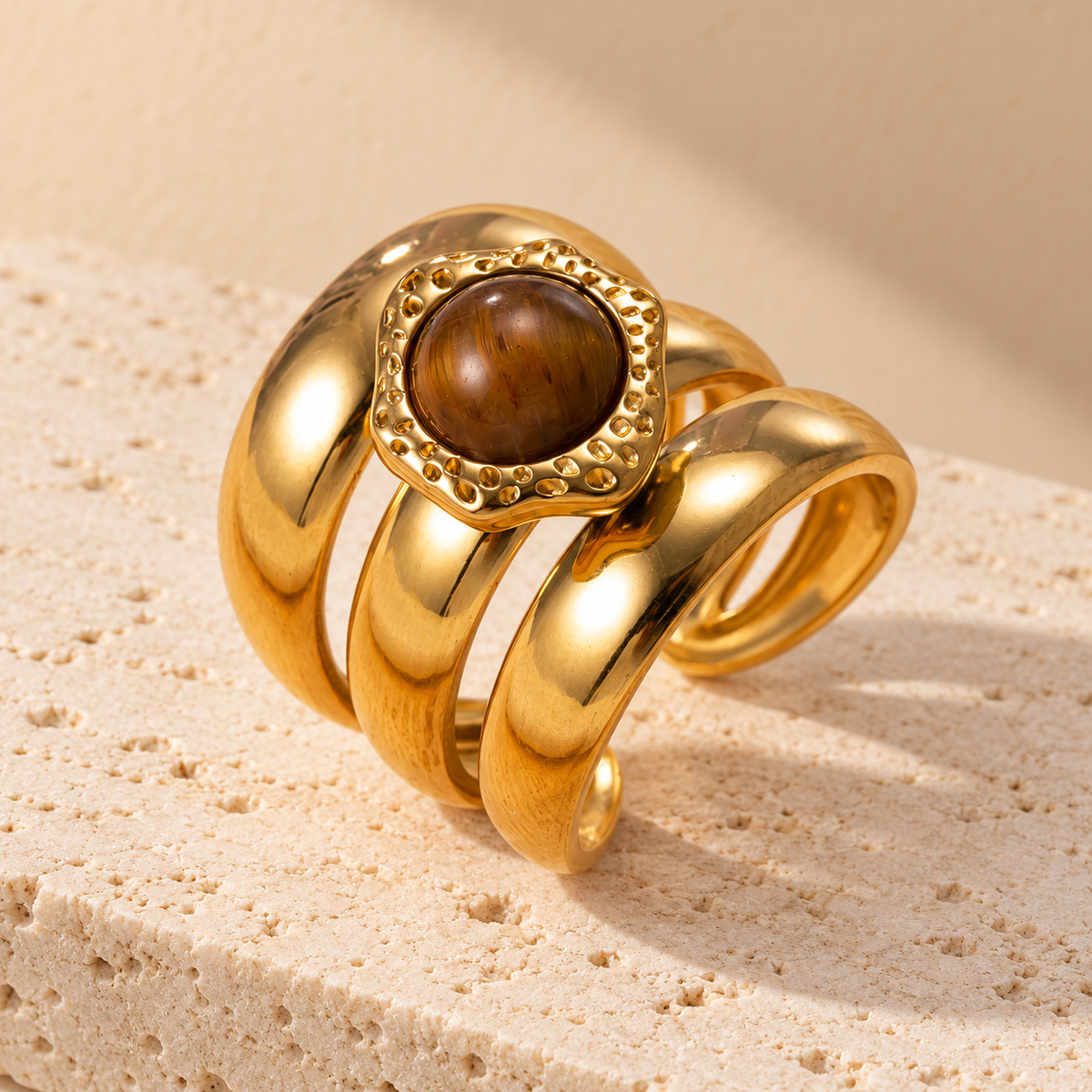 Detail van de Amber Sculptural Ring op een lichte stenen ondergrond