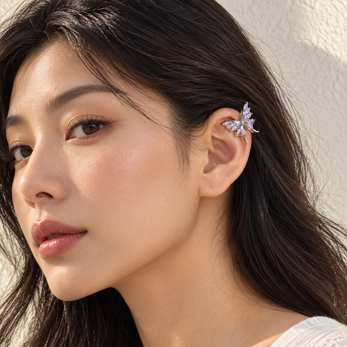 Gold Butterfly Ear Clip gedragen door een vrouw, met het sieraad duidelijk in beeld