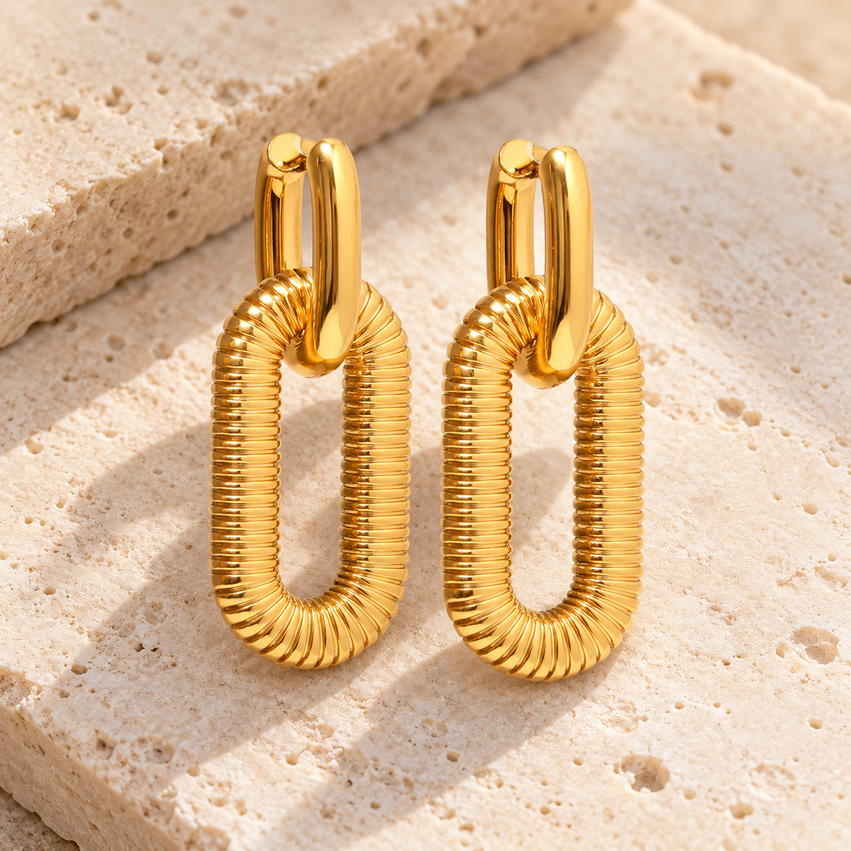 Oval Glow Earrings — pale beige stone background